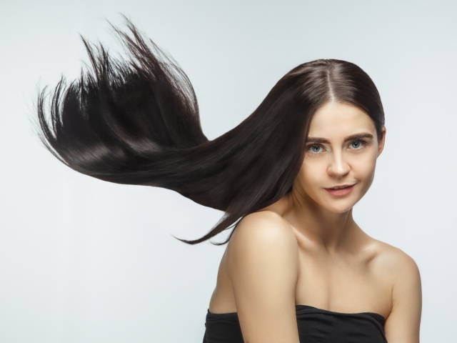 Длинные шелковистые волосы молодой брюнетки 