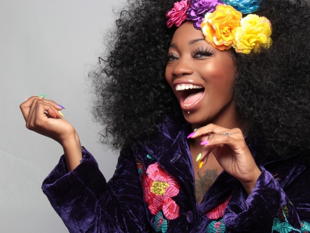 Улыбающаяся темнокожая девушка с цветами в волосах 
