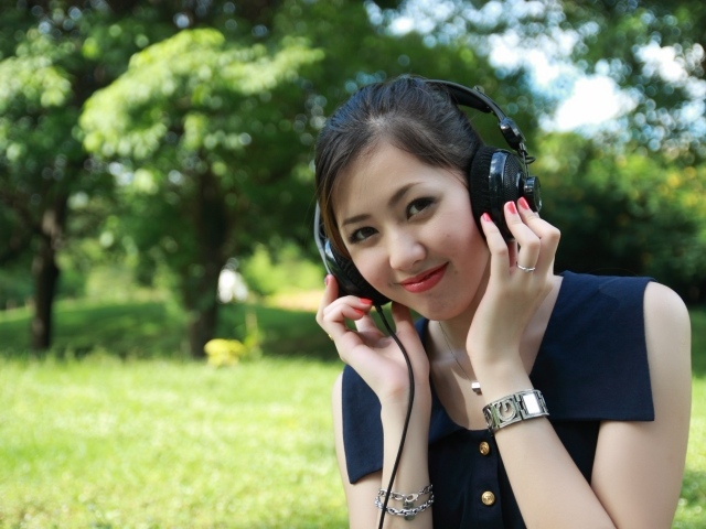 Молодая девушка азиатка в больших наушниках 