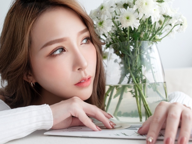 Молодая азиатка с букетом белой хризантемы в вазе