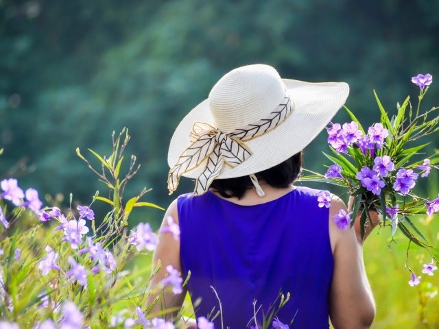 Молодая девушка в шляпе с букетом цветов 