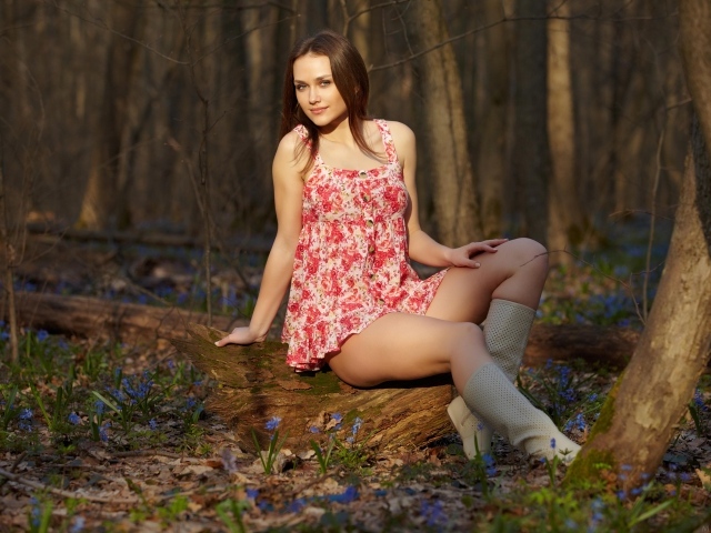 Молодая девушка в коротком платье в лесу весной