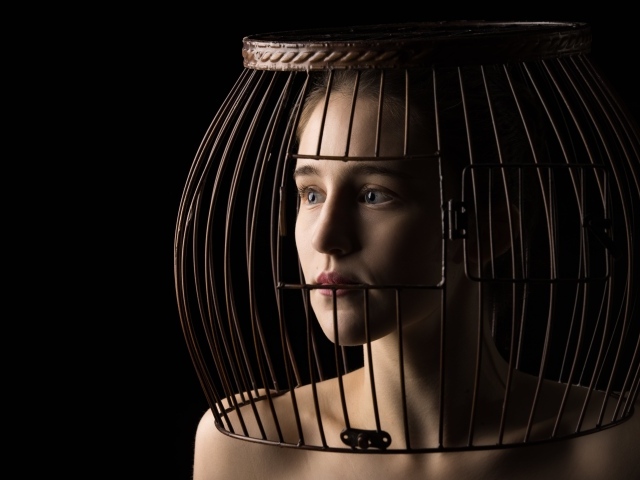 Молодая девушка с клеткой на голове 