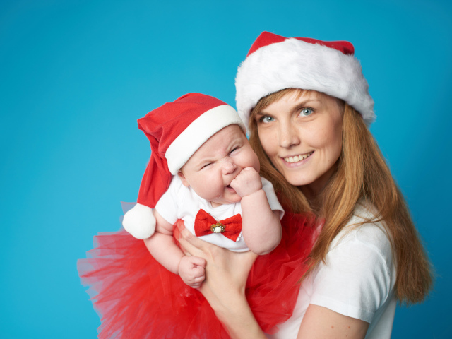 Девушка с ребенком в новогодних костюмах на голубом фоне