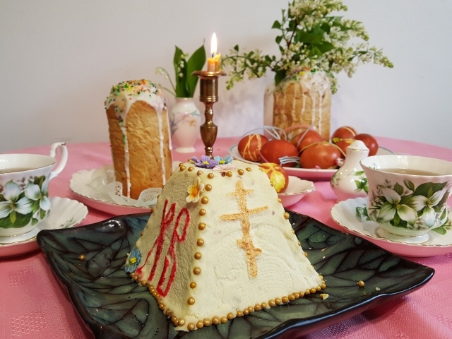 Творожная паска на столе с крашеными яйцами и чаем