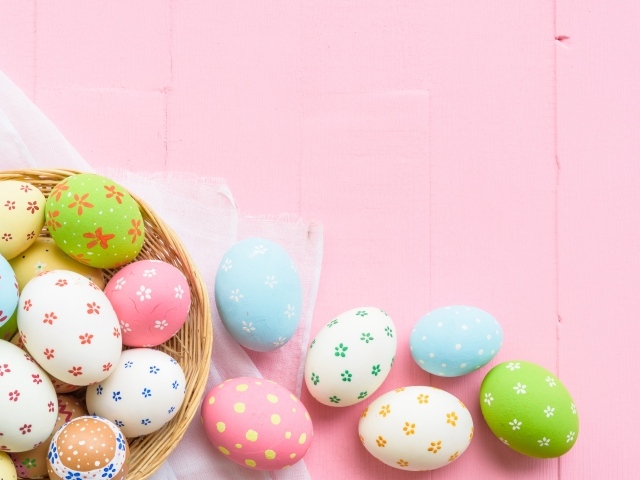 Разноцветные пасхальные яйца на розовом фоне