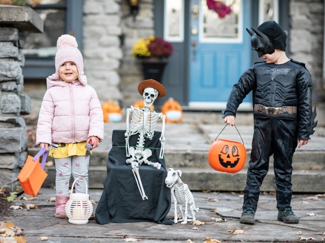 Маленькие дети со скелетом на праздник Хэллоуин