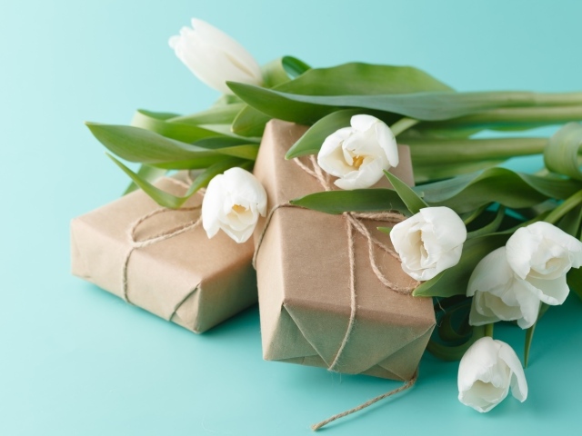 Белые тюльпаны  и подарки на голубом фоне на Международный женский день 8 марта