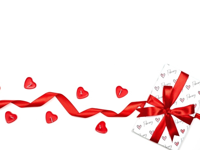 Подарок с красной лентой и свечами на белом фоне на День Святого Валентина