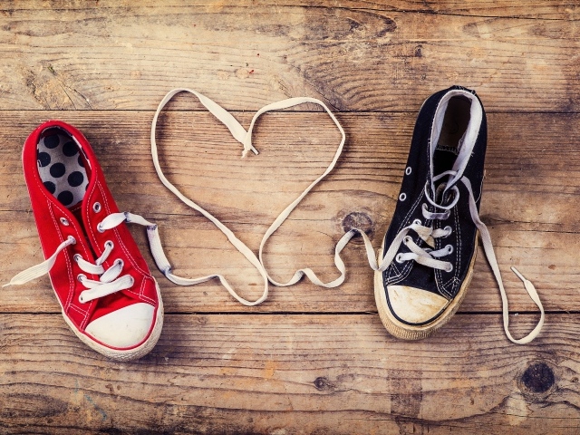 Сердце из шнурков кед на деревянном столе 