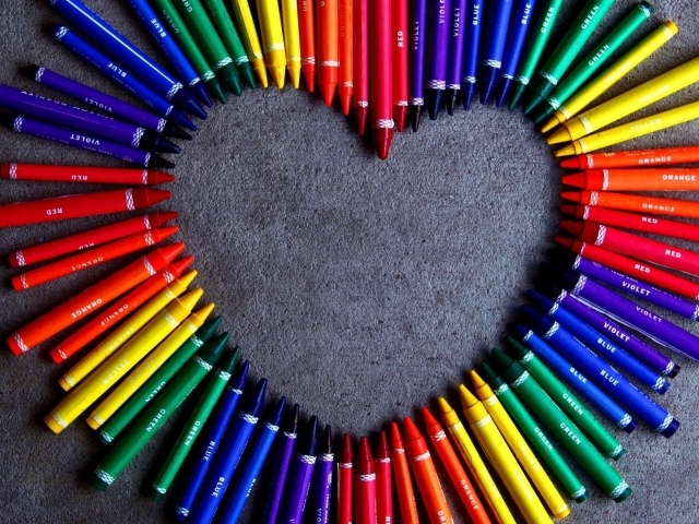 Сердце  из разноцветных карандаш на сером фоне 