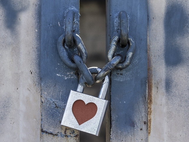 Железный замок с сердцем висит на цепи 