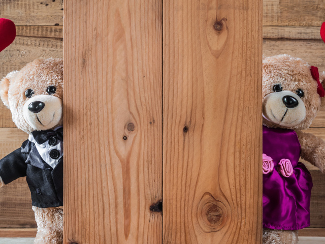 Два плюшевых медведя с сердечками у стены