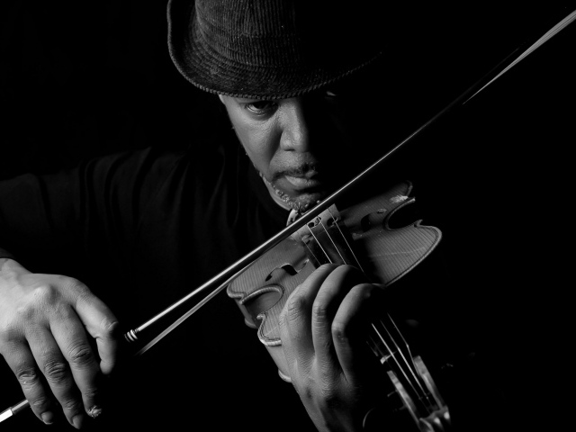 Темнокожий мужчина играет на скрипке 