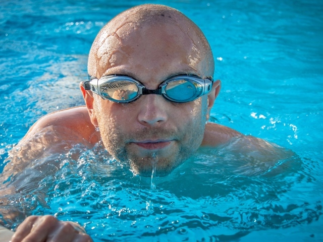 Мужчина пловец в очках в бассейне 