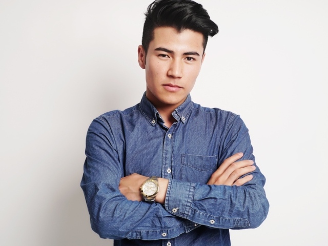 Мужчина в синей рубашке на сером фоне 