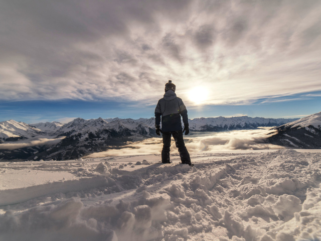 Человек в заснеженных горах в лучах солнца
