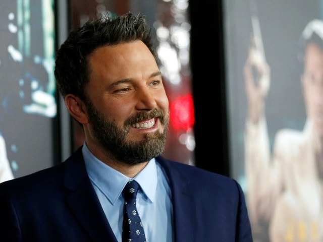 Улыбающийся мужчина, актер Бен Аффлек в костюме