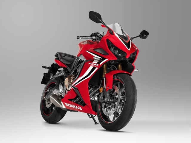 Красный мотоцикл Honda CBR 650 RR, 2021 года на сером фоне