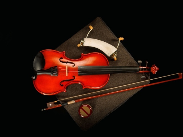 Красная скрипка со смычком на черном фоне