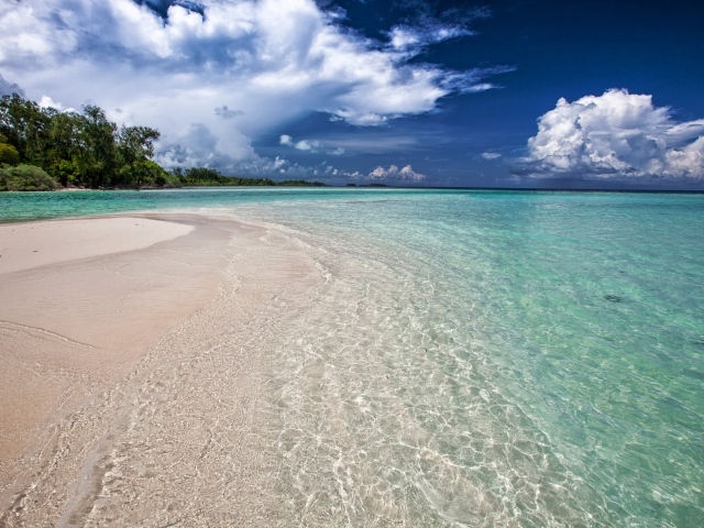Чистая голубая вода на пляже с желтым песком