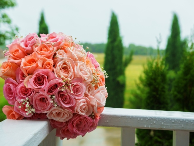 Красивый свадебный букет розовых роз на белых перилах