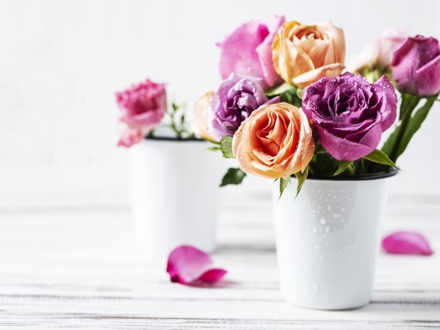 Букет разноцветных роз в белой вазе на столе