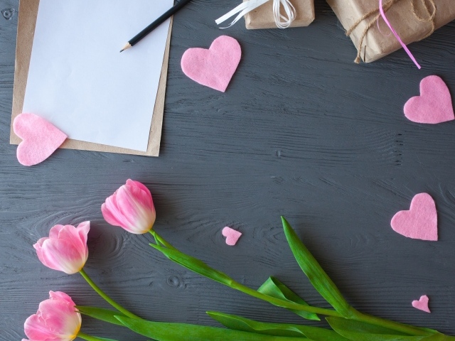 Тюльпаны, лист бумаги и сердечки на сером столе