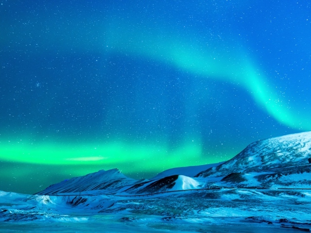 Небо с северным сиянием над заснеженными горами