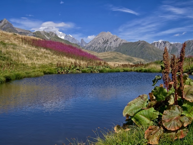 Яркое солнце над горами и озером