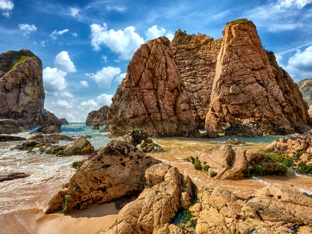 Большие каменные возвышенности в море под голубым небом 