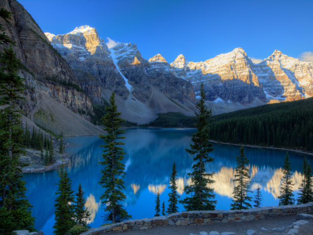 Каменные горы с заснеженными вершинами у озера 