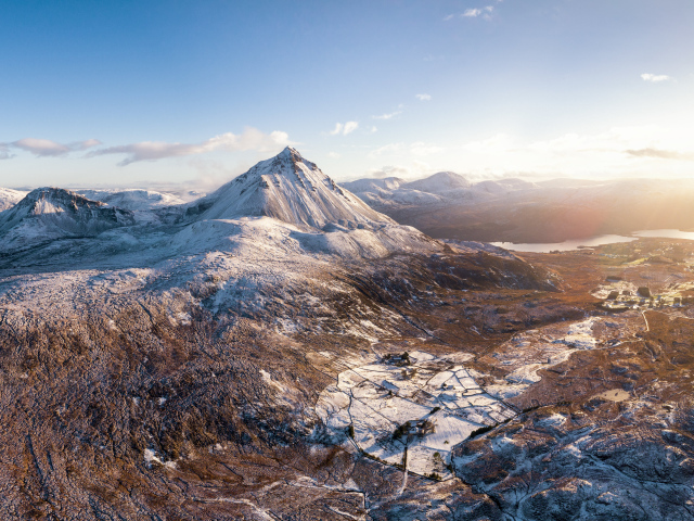 Вид на высокие заснеженные горы в лучах солнца