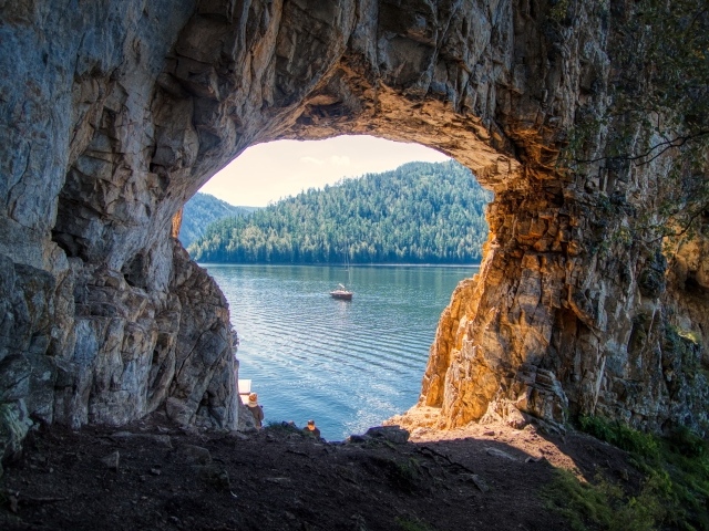 Проход арка в скале ведет к озеру