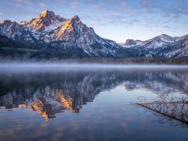 Туман над холодным озером на фоне гор 