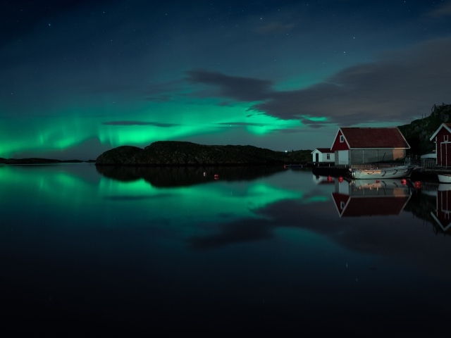 Дома на берегу озера на фоне полярного сияния 