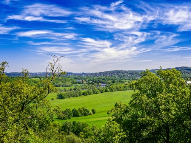 Красивый вид на зеленые холмы под голубым небом летом