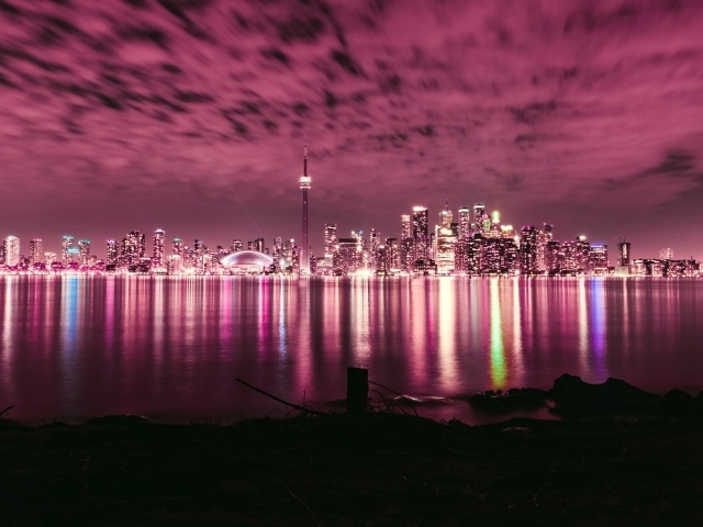 Ночной город под голубым небом отражается в воде 