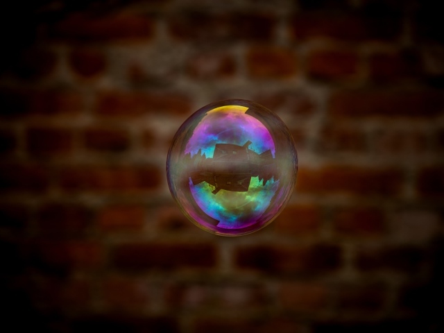 Мыльный пузырь в воздухе на фоне стены