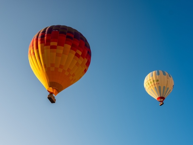 Два больших красочных воздушных шара в голубом небе