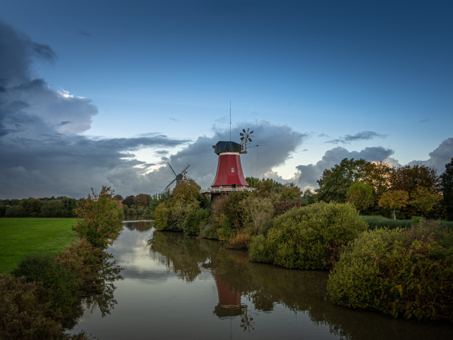 Мельница на берегу реки под красивым небом в сумерках