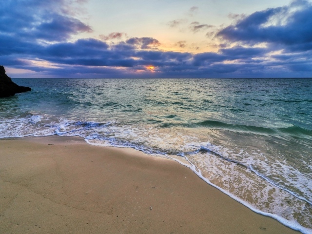 Голубая морская вода на песке на закате солнца