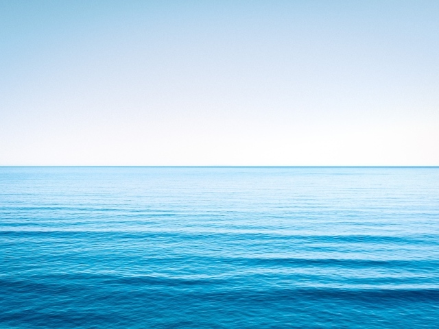 Спокойная голубая морская вода под голубым небом 