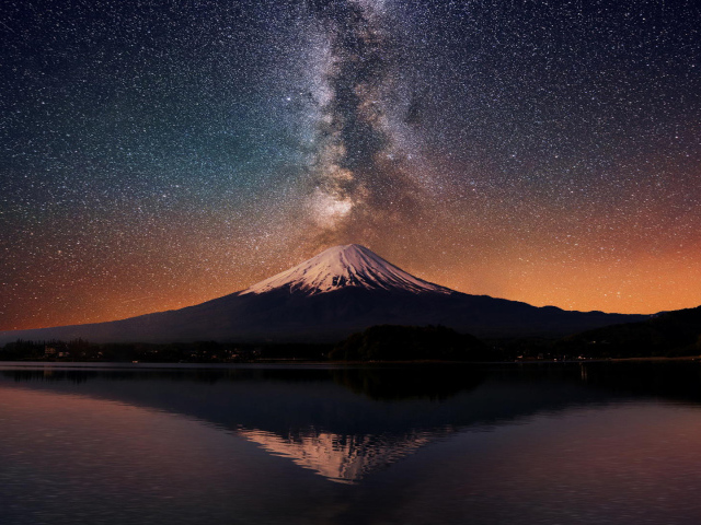 Заснеженная вершина вулкана под звездным небом