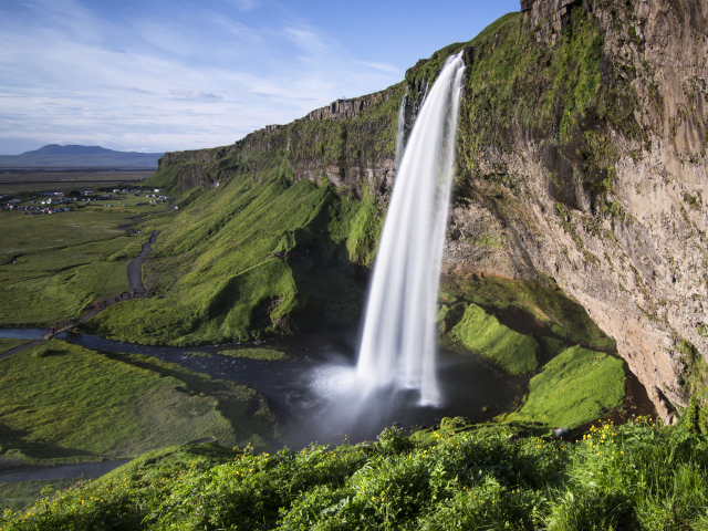 Быстрый водопад Сельяландсфосс стекает со скалы, Исландия