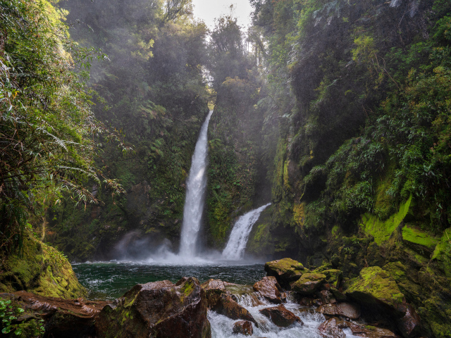 Водопад стекает со скалы в горную реку