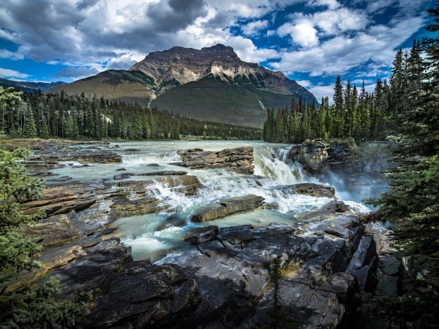 Водопад стекает по камням на фоне горы, Канада