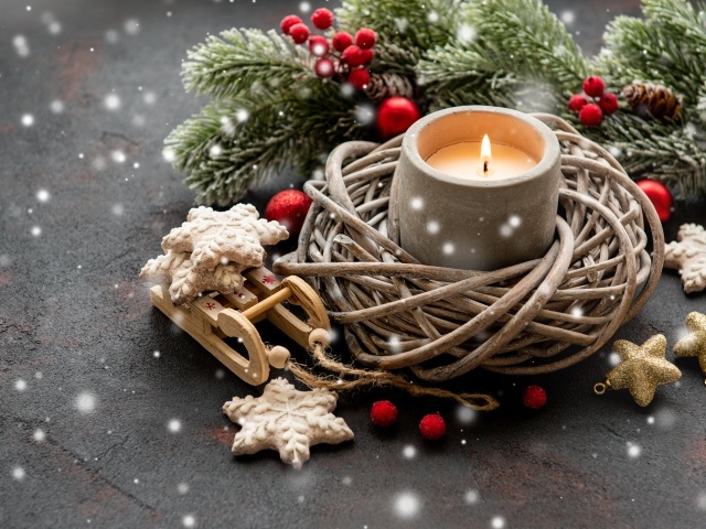 Зажженная свеча с еловой веткой и украшениями