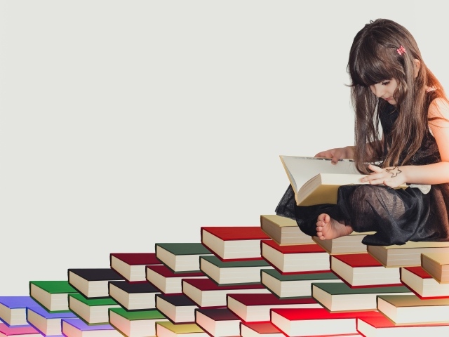 Маленькая девочка сидит на горе книг 