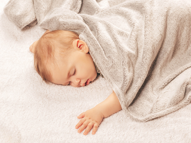 Грудной спящий ребенок под одеялом 